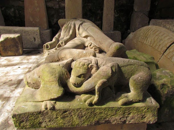 A wyvern and dog fight at the foot of Sir John Conyers' effigy, in Sockburn